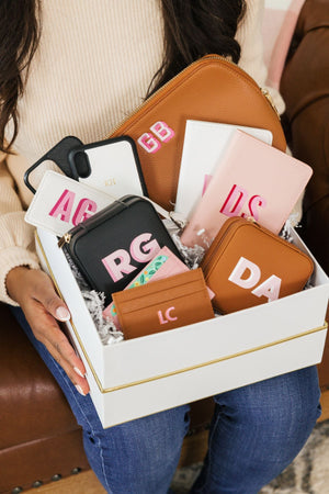A woman holds a box of personalized gifts.