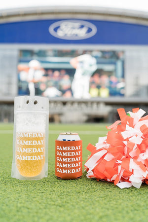 A gameday party pouch and koozie are placed on a turf next to a pom pom.