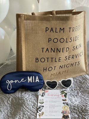An assortment of products are laid out for a party in Miami including a Miami City Jute and a "gone MIA" sleep mask.