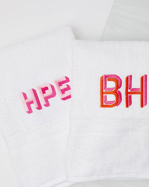 Two white guests towels with custom  pink monograms