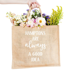 A custom jute bag reads "Hamptons Are Always A Good Idea" on the front