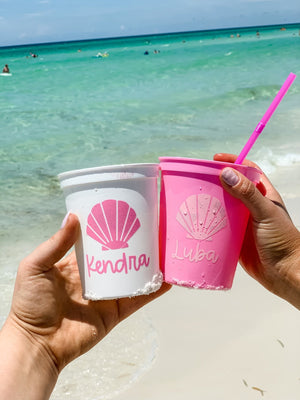 Two women cheers their shell-themed stadium cups together