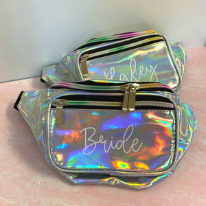 Two silver metallic fanny packs are customized with script white names