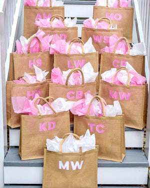 Welcome bags filled with pink tissue paper sit on a staircase