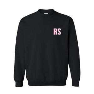 A black sweatshirt with "RS" monogrammed on the front chest