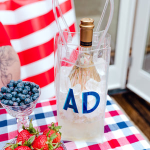 A wine bottle sits in a custom wine bag with initials at a Fourth of July Party.