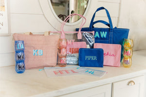 A collection of bags and cups are personalized with names and monograms.