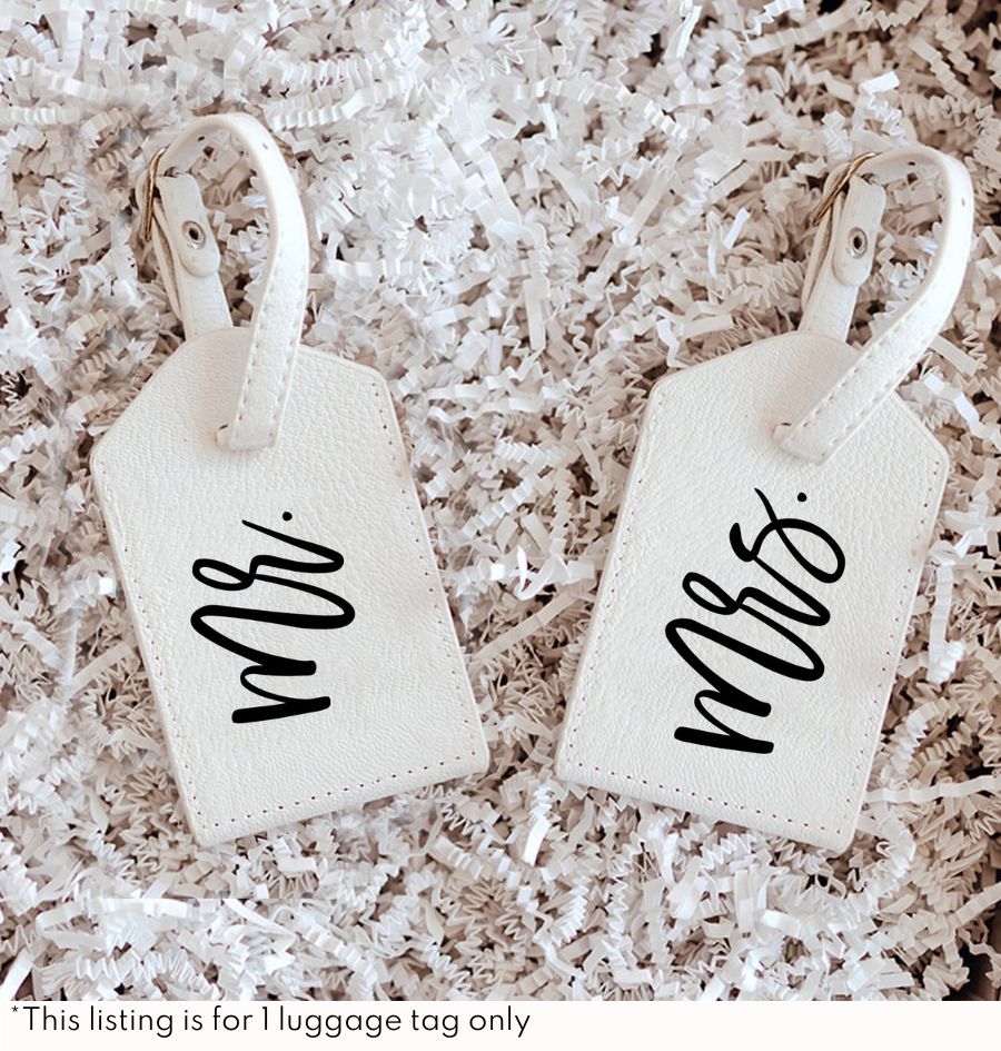 Two black luggage tags with white lettering that read "Mr. & Mrs."