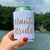 A woman holds up a white can cooler which says "Nauti Bride" in a gold glitter font.