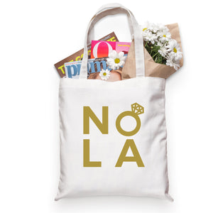 A cotton tote is customized with a gold NOLA design.