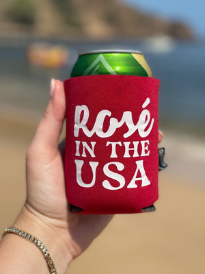 A woman holds a red can cooler that says "Rose in the USA"