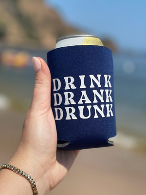 A woman holds a blue can cooler that says "Drink Drank Drunk"