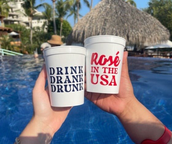 A set of four white-colored stadium cups customized with patriotic drinking phrases