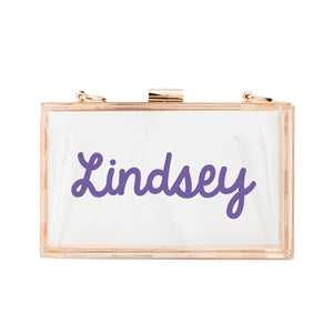 A personalized acrylic stadium bag reads "Lindsey" in purple