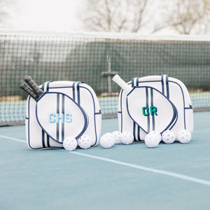 Two blue and white pickleball bags are customized with embroidered monograms.