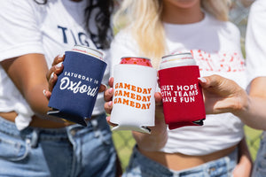 Women hold out drinks in their gameday can coolers
