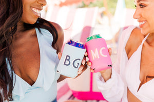 Two women drink from cans cooled in a monogrammed can cooler