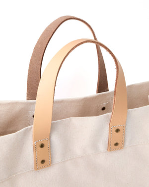 A weekender tote is zoomed in on to show the straps and hardware on the bag.
