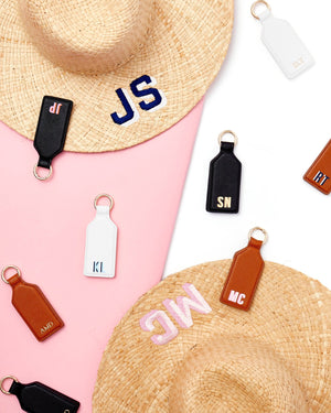 A variety of leather hat clips are personalized with different monograms.