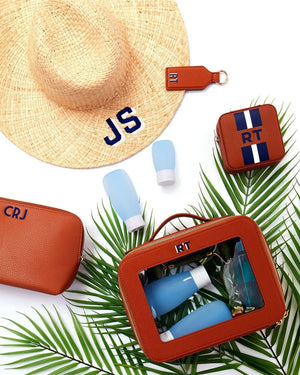 An array of tan leather products are customized with matching navy monograms.