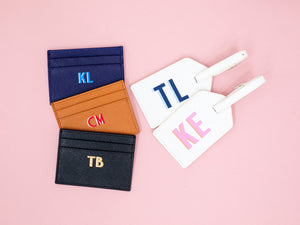 A group of cardholders and luggage tags are customized with fun monograms