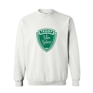 A white sweatshirt is customized with a green troop logo