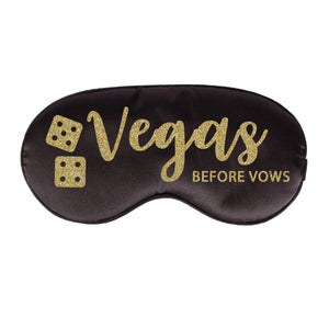 A black sleep mask is customized with a design that says "Vegas Before Vows" in a gold glitter font.